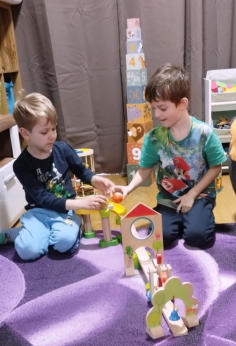 Zwei Kinder bauen gemeinsam mit buntem Holzspielzeug