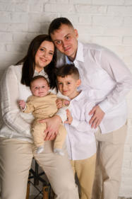 Familienfoto vor einer weißen Ziegelwand